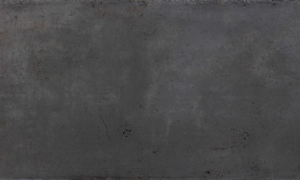 A dark gray, almost black, polished concrete floor. The floor is dull, with a few scuff marks throughout.